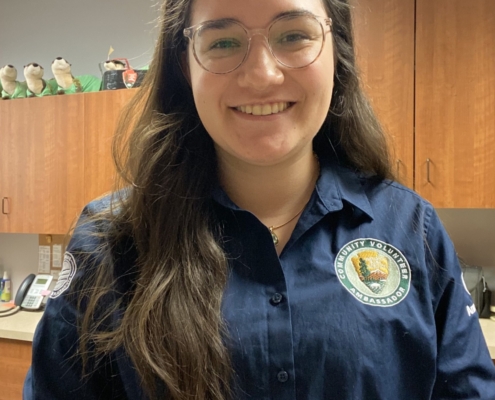 A young woman faces the camera and smiles in an office