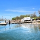 A view of a boat ramp with a multiple boats docked and a garbage truck parked on the ramp.