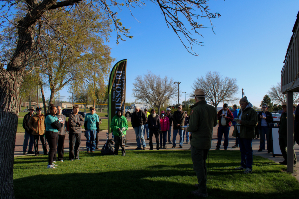 a park ranger stands in front of a crowd of people outside