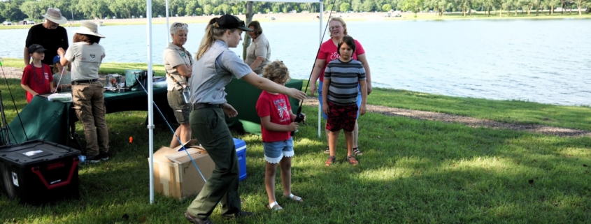A group of people gathered under a tent next to a lake
