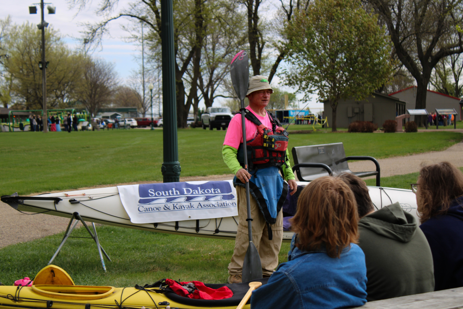 A man talks to student while wearing paddling gear.