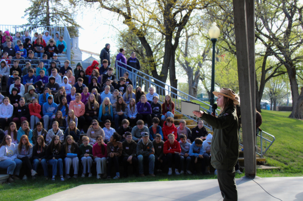 A park ranger speaks to a amphitheater full of students