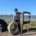 A young boy poses with a tire and wooden structure